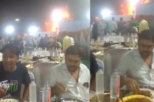 En plena boda en la India, dos hombres permanecen comiendo mientras se incendia una carpa